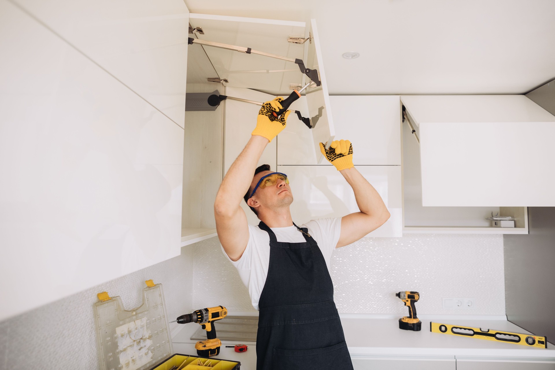 Maintenance man installing kitchen furniture